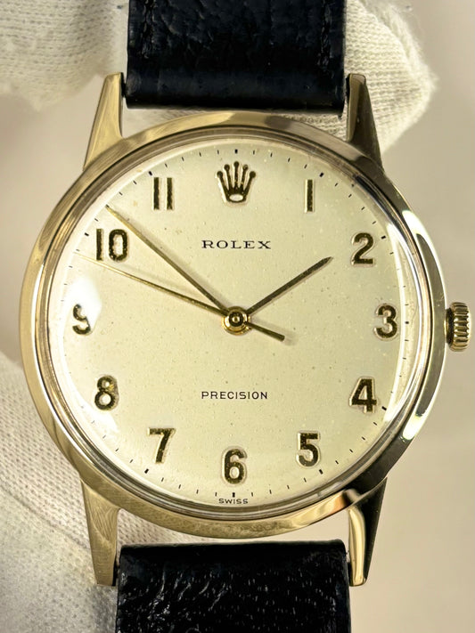 Close-up of the 1955 Rolex Precision timepiece, model 12865 highlighting the pristine dial and polished 9ct gold case of this classic timekeeper.