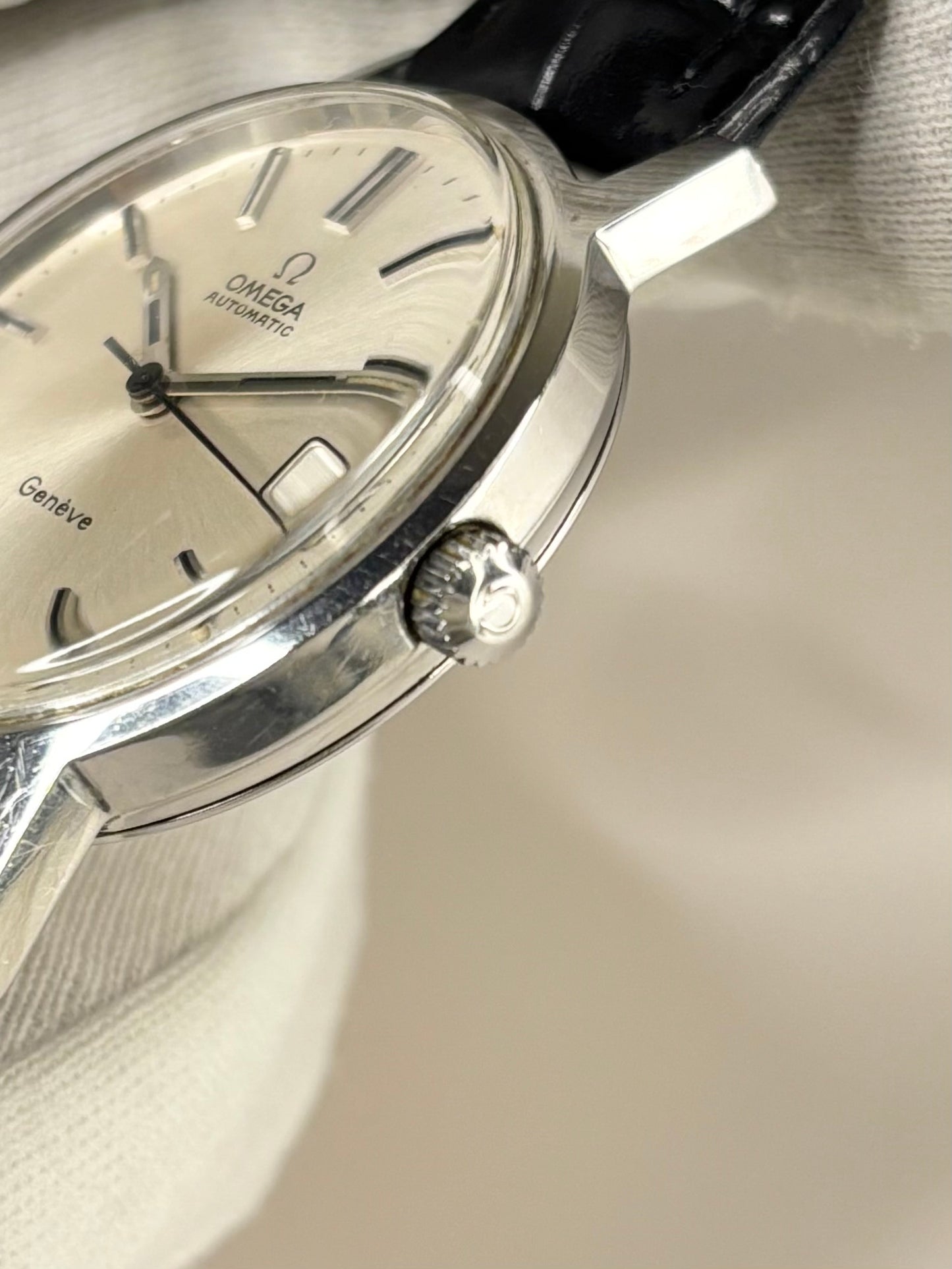Side view of Omega Genève 1970s men’s dress watch, stainless steel case, automatic cal. 1012 omega signed crown