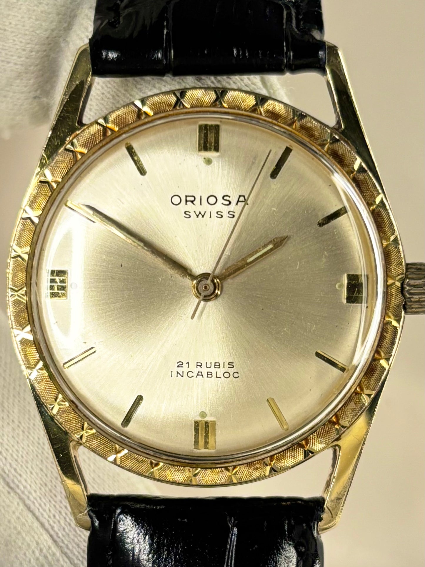 Close-up of Oriosa vintage manual movement watch with gold-plated case and sunburst dial