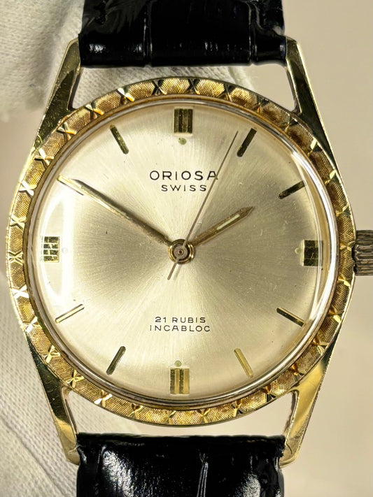 Close-up of Oriosa vintage manual movement watch with gold-plated case and sunburst dial
