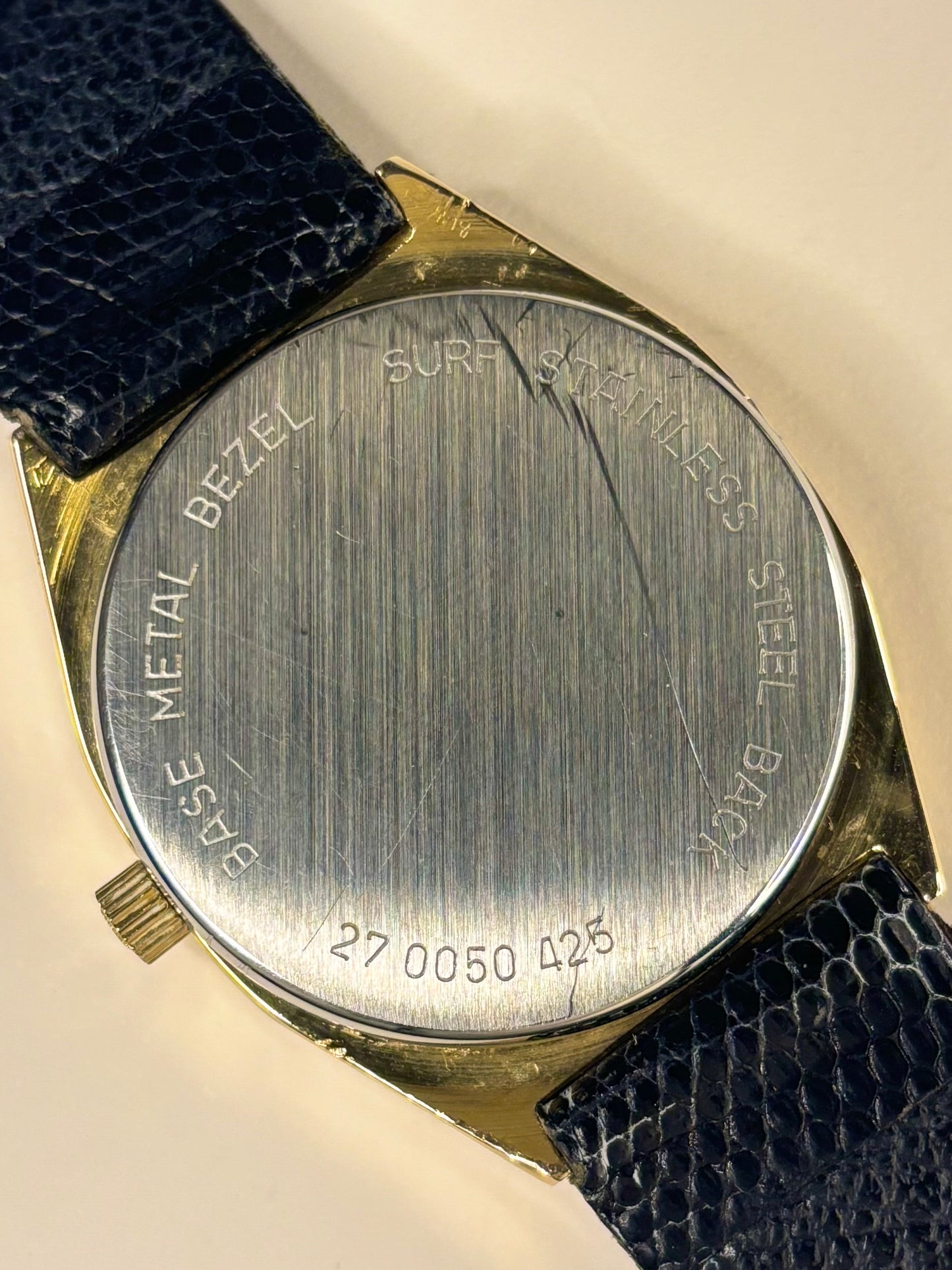 Close-up of the Zenith 1970s caseback featuring a black dial and polished gold-plated case as a precise quartz timekeeper.