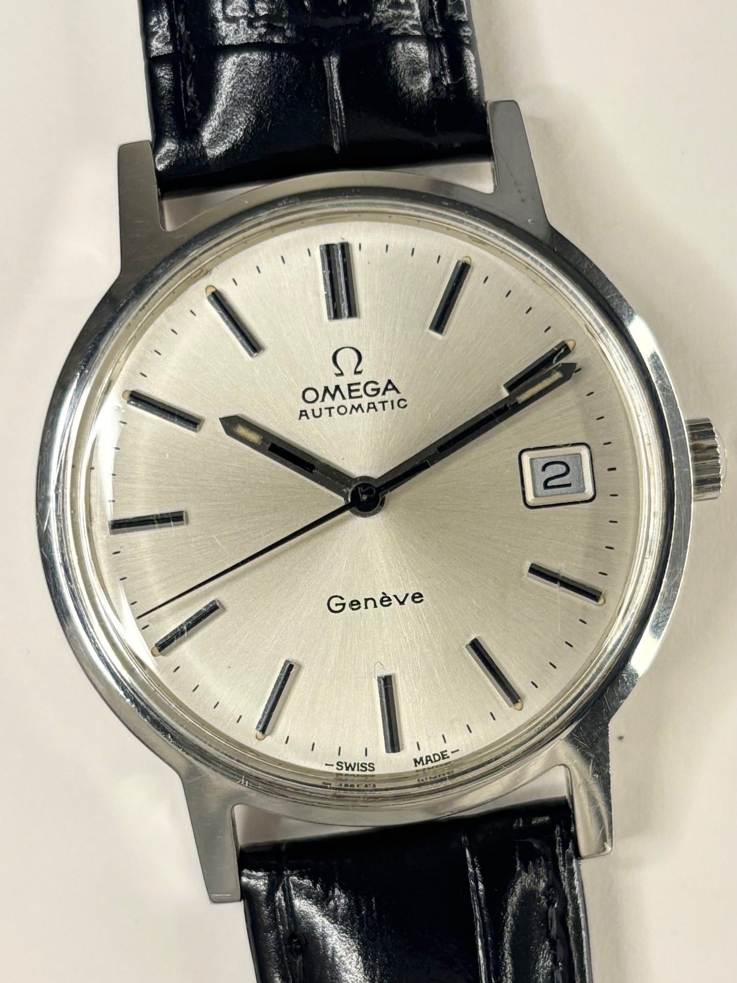 Close-up of Omega Genève vintage automatic watch with white sunburst dial, ref. 166.0163