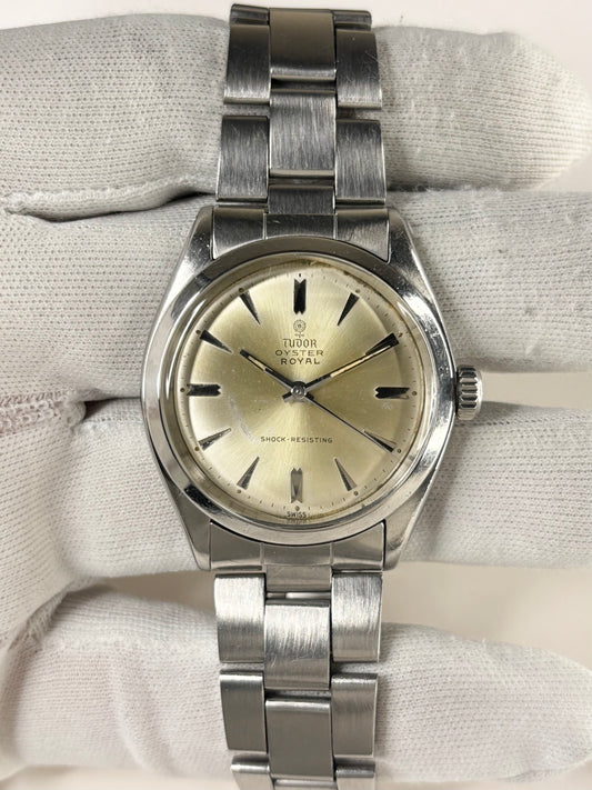 Silver Tudor watch on a textured fabric background