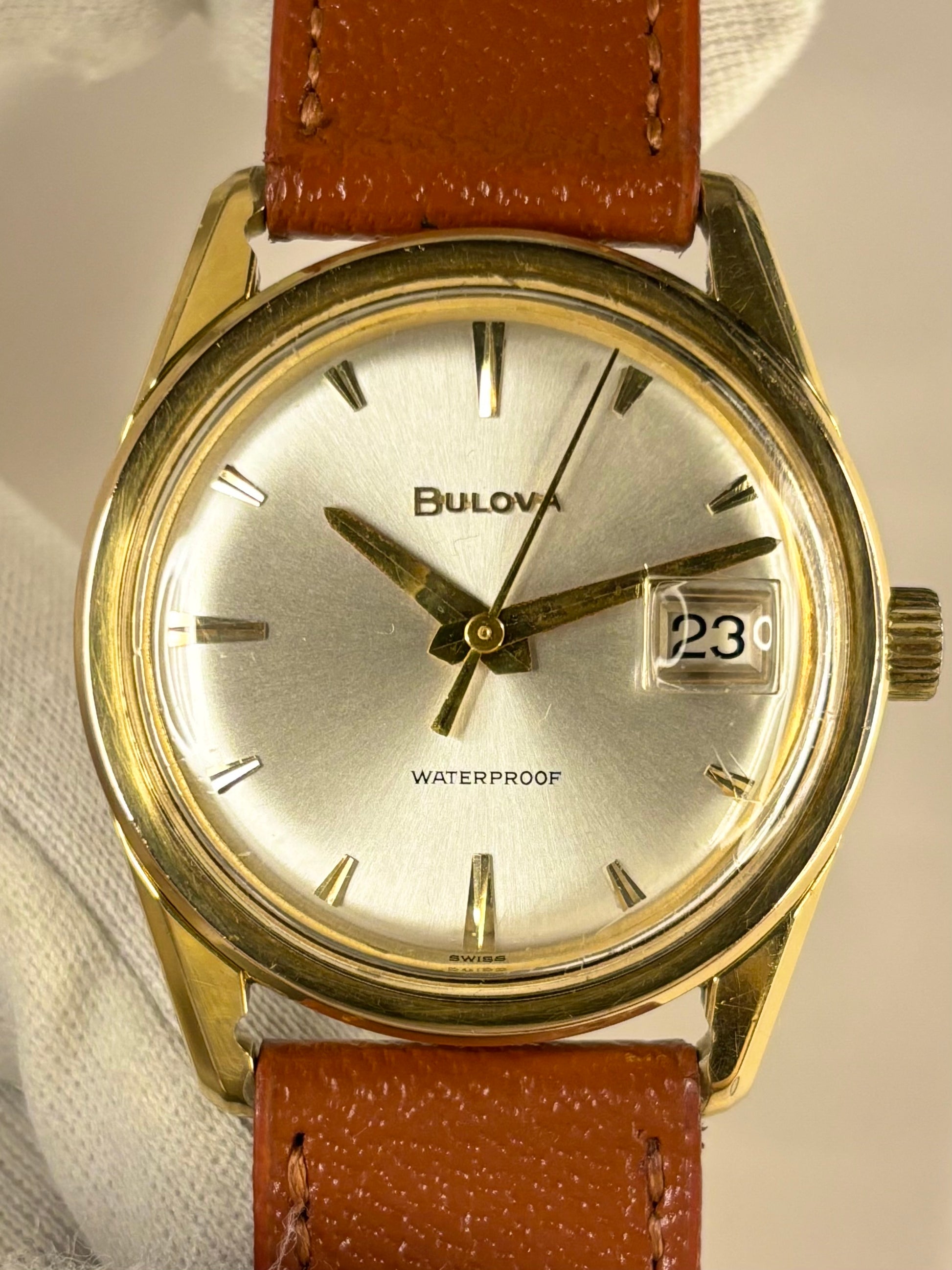 Bulova men’s dress timepiece from the 1970s with white sunburst dial and gold-plated case, presented as a refined vintage timekeeper