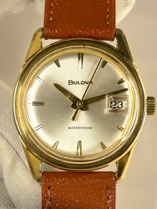 Bulova men’s dress timepiece from the 1970s with white sunburst dial and gold-plated case, presented as a refined vintage timekeeper