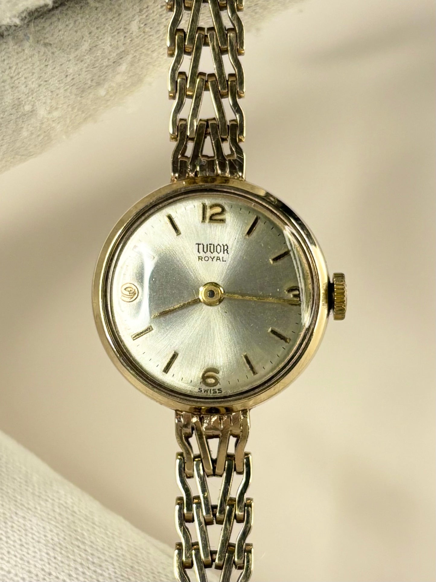 Close-up of the Tudor 1960s ladies timepiece featuring a polished 9ct gold case and radiant sunburst dial, photographed as a classic manual timekeeper.