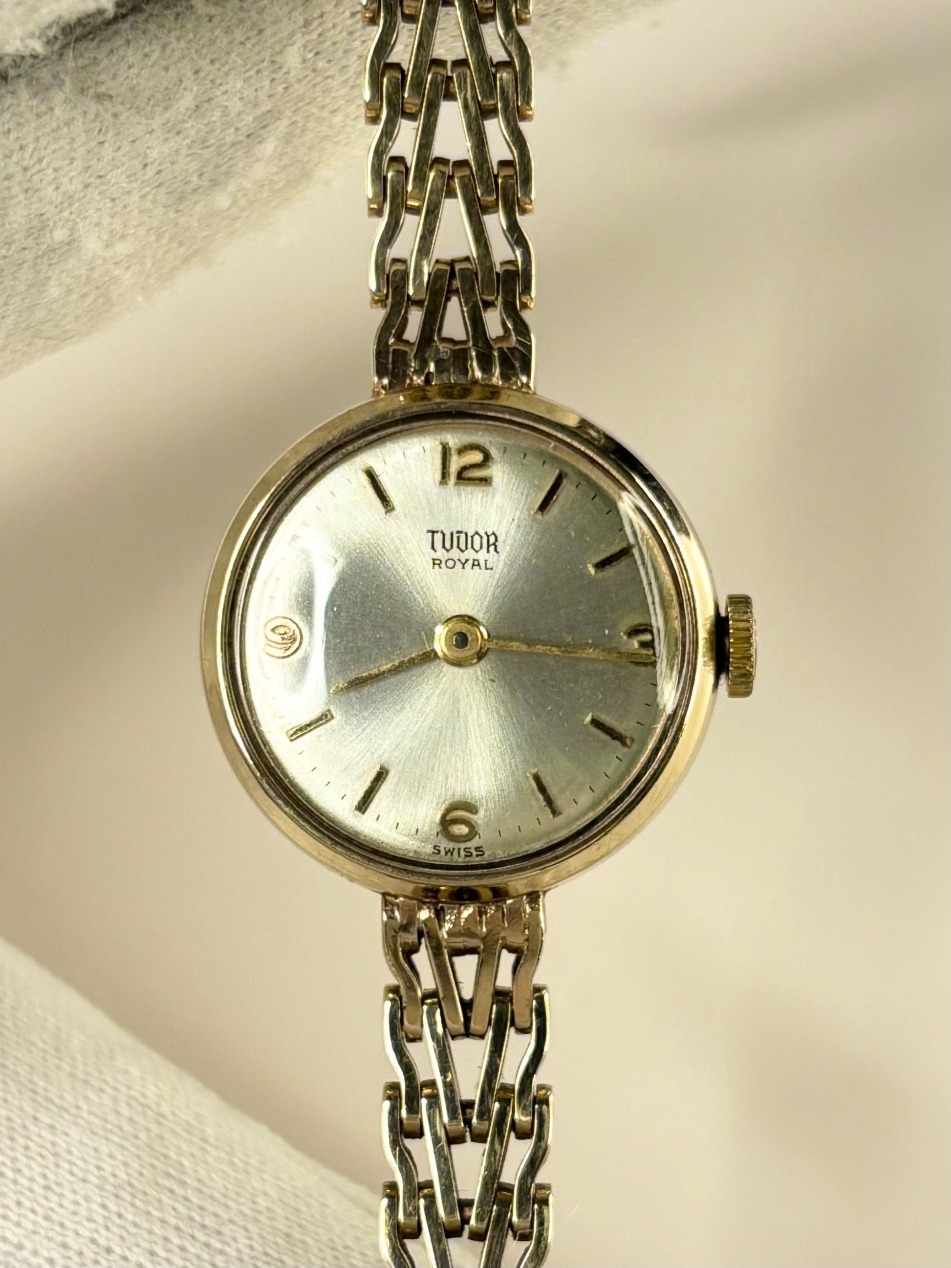 Close-up of the Tudor 1960s ladies timepiece featuring a polished 9ct gold case and radiant sunburst dial, photographed as a classic manual timekeeper.