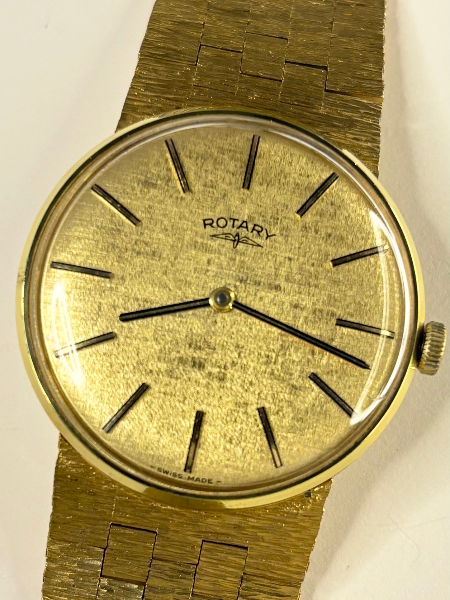 Close-up of Rotary vintage dress watch with gold-plated case and textured bark effect strap