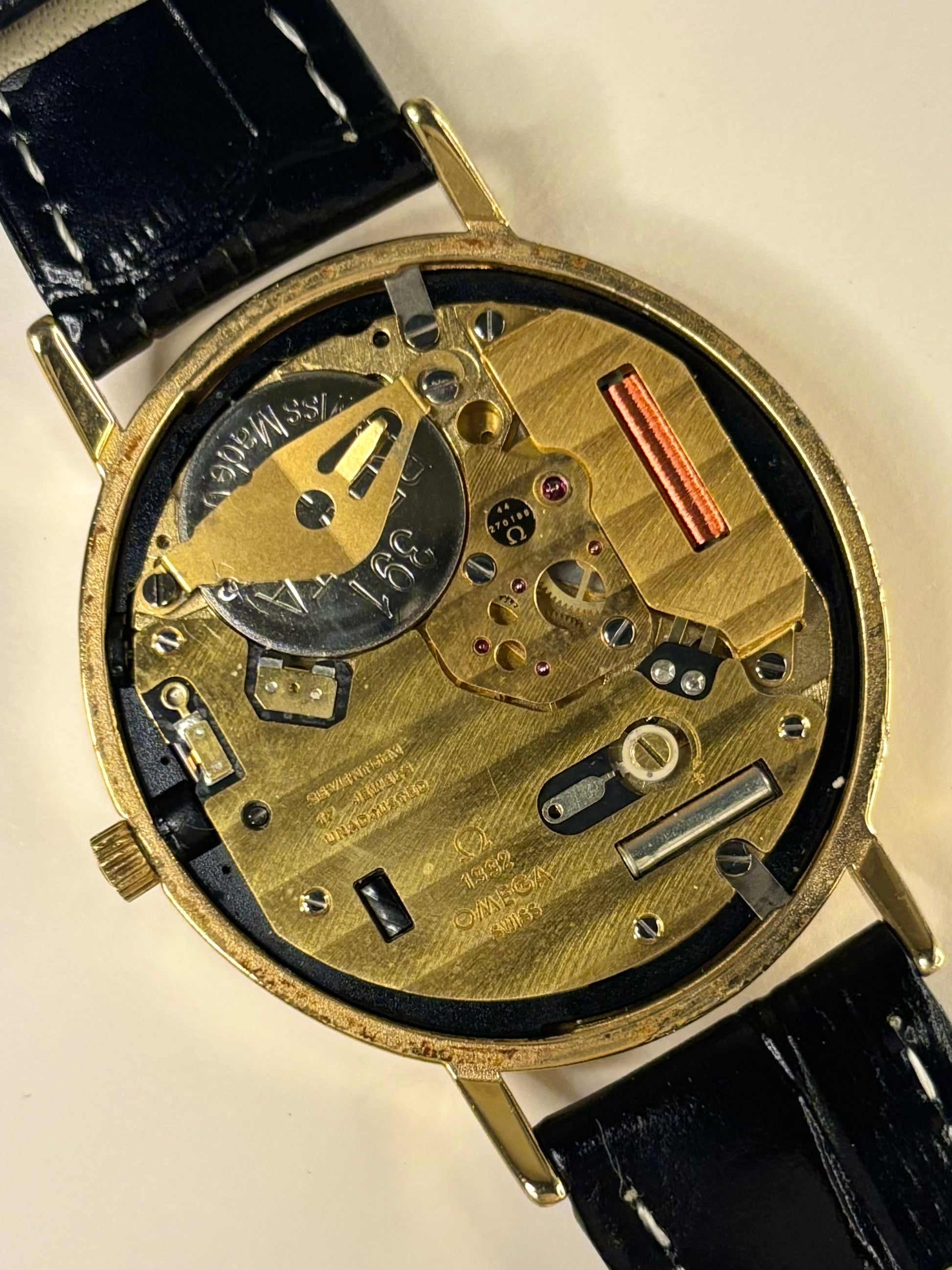 Detailed dial shot of Omega De Ville mechanism timepiece model 192.0057 featuring a black dial and precise calibre 1332 timekeeper
