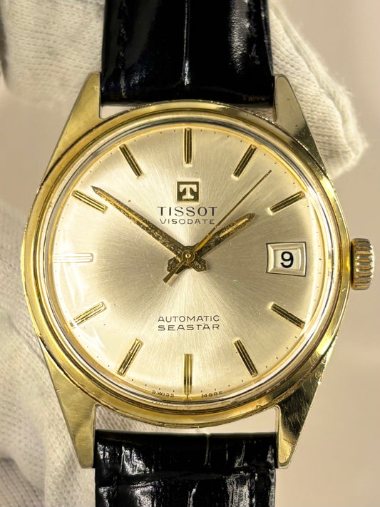 Close-up of the Tissot Seastar timepiece from c.1973, showing its radiant white sunburst dial and polished gold-plated case as a refined automatic timekeeper
