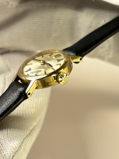 Side profile of Tissot Ref. 17073-31 1957 ladies vintage timekeeper with slim 18ct gold case styling Tissot signed crown