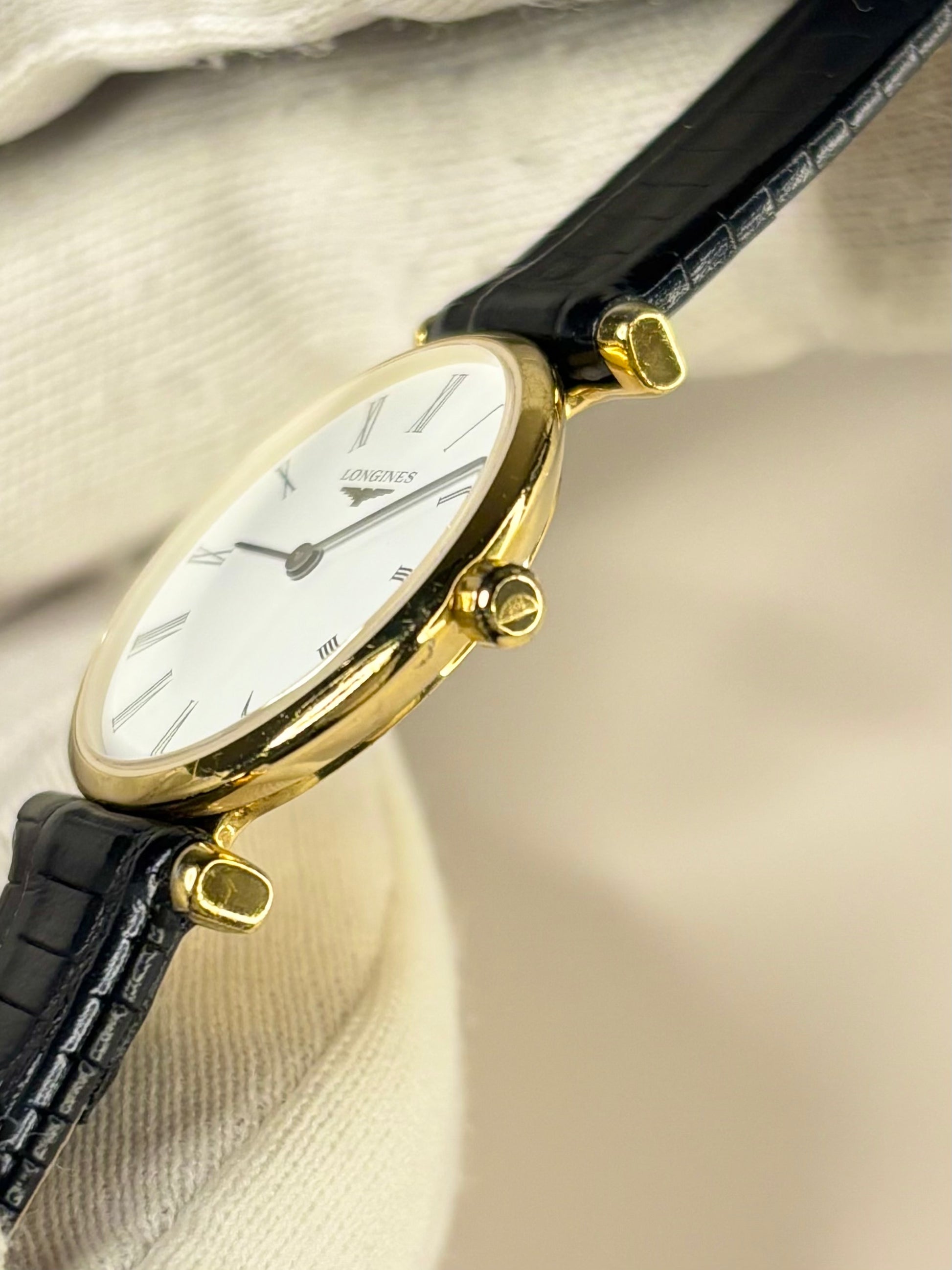 Close-up of the Longines ladies timepiece with movement L4.209.2, showing the clean white dial and gold-plated case of this well-preserved vintage timekeeper. side profile longines signed crown 