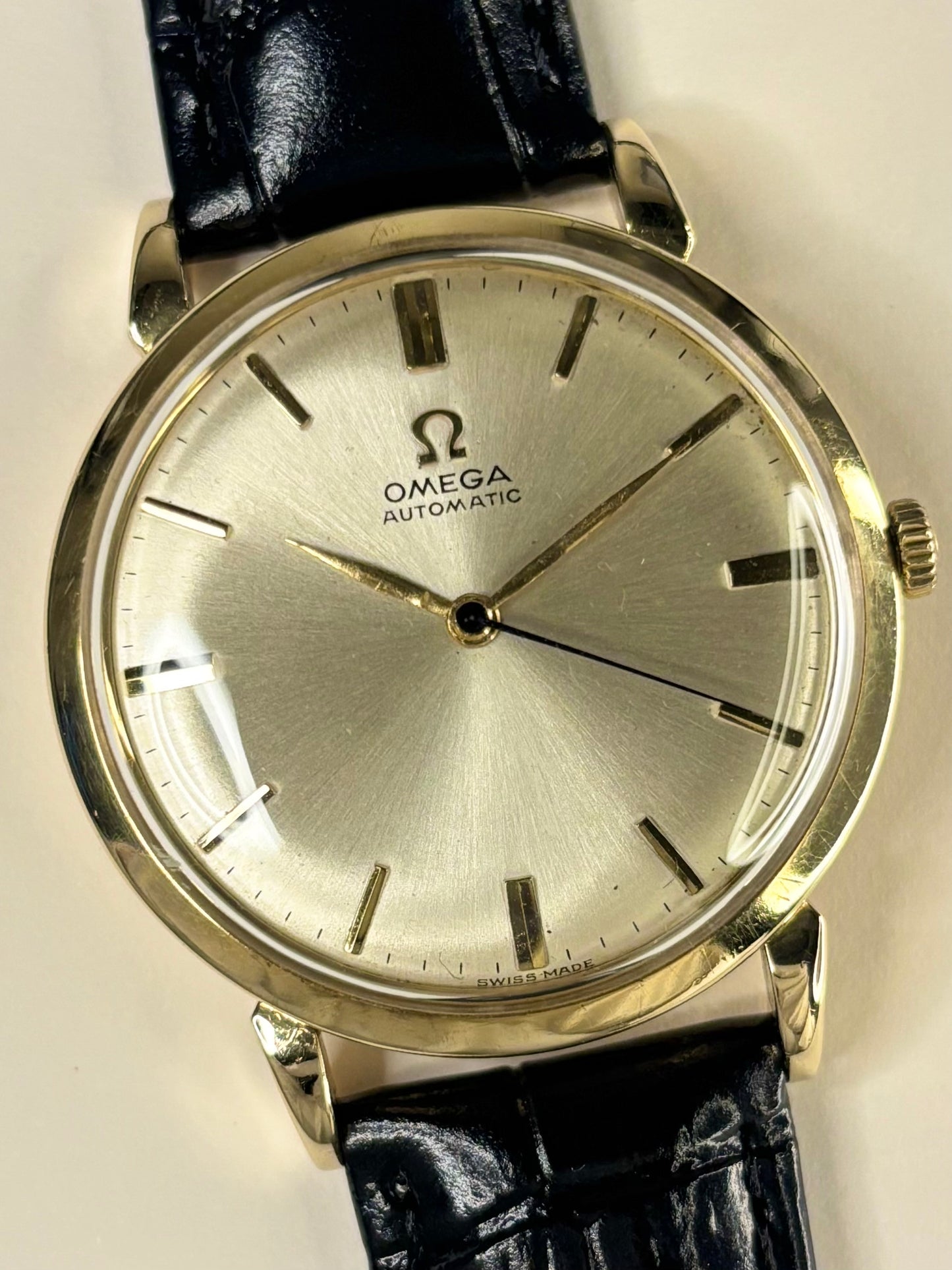 Close-up of Omega 14ct gold vintage men’s watch, automatic movement, sunburst dial