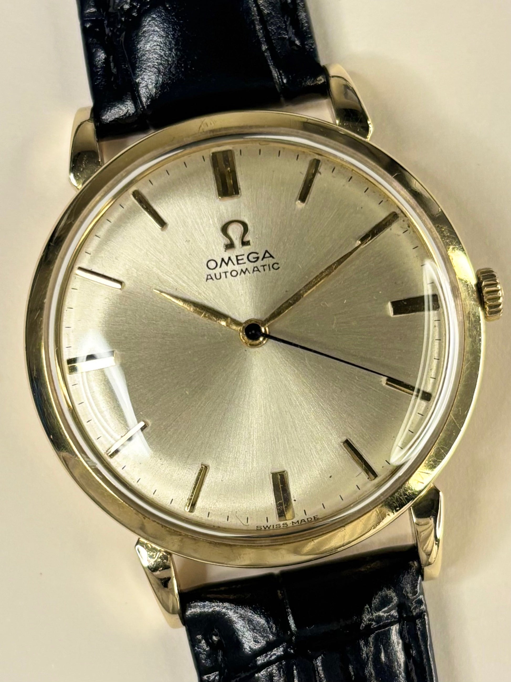 Close-up of Omega 14ct gold vintage men’s watch, automatic movement, sunburst dial