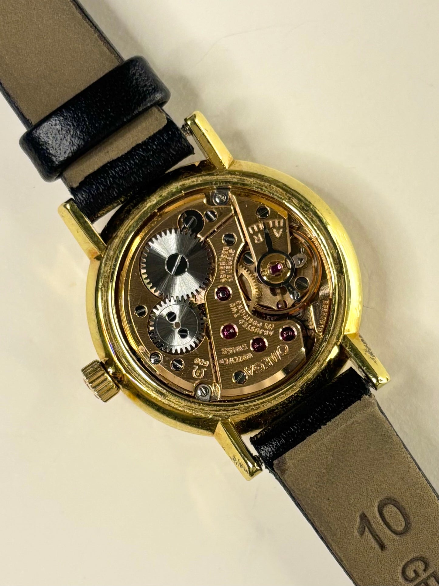 mechanism image of the Omega 511.215 ladies timepiece showcasing its crisp white dial and gold-plated case as a timeless manual-wind timekeeper.