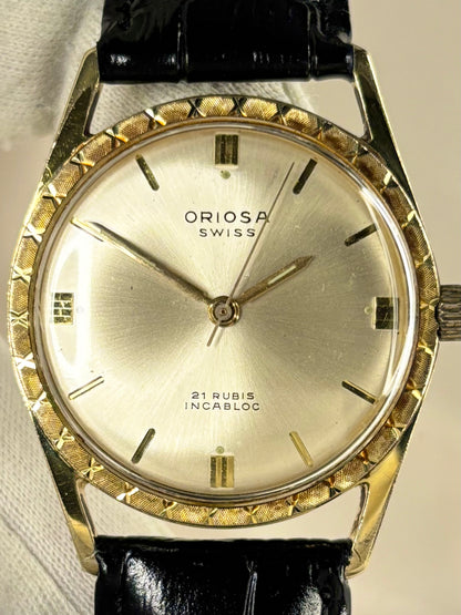 Close-up of Oriosa vintage manual movement watch with gold-plated case and sunburst dial
