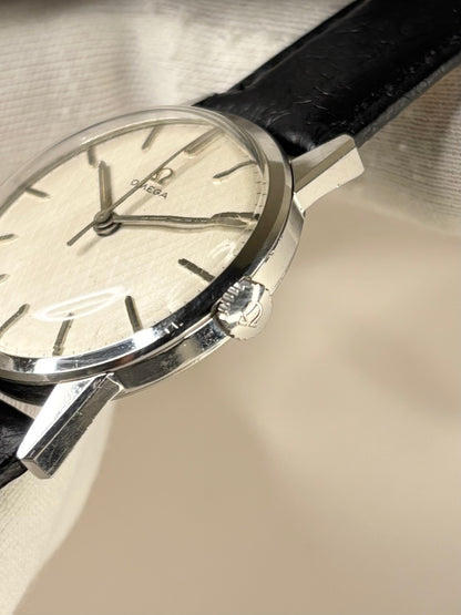 Side profile of Omega Ref. 1961 men’s vintage dress timekeeper with slim 1961 stainless steel case styling omega signed crown