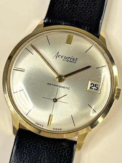 Accurist watch with black leather strap and white dial on a white background