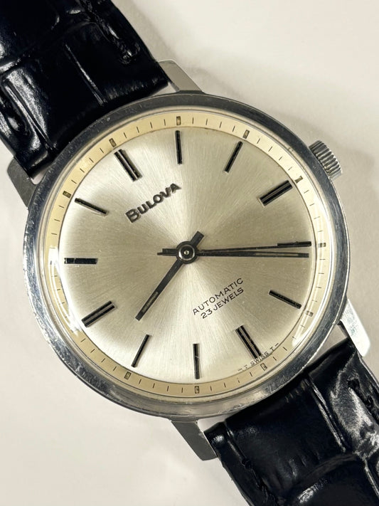 Vintage c.1973 Bulova automatic timepiece – men's stainless steel dress watch with white sunburst dial, in good condition with only minor age-appropriate marks.