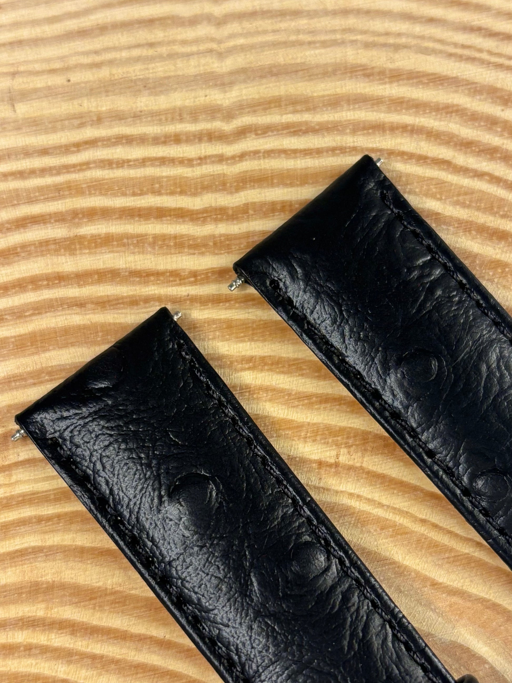 Premium handmade luxury black ostrich grain leather watch strap showing natural quill follicle pattern
